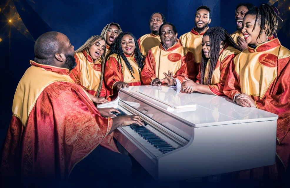 Het koor Golden Voices of Gospel in rode en gouden gewaden, zingend rond een witte vleugel